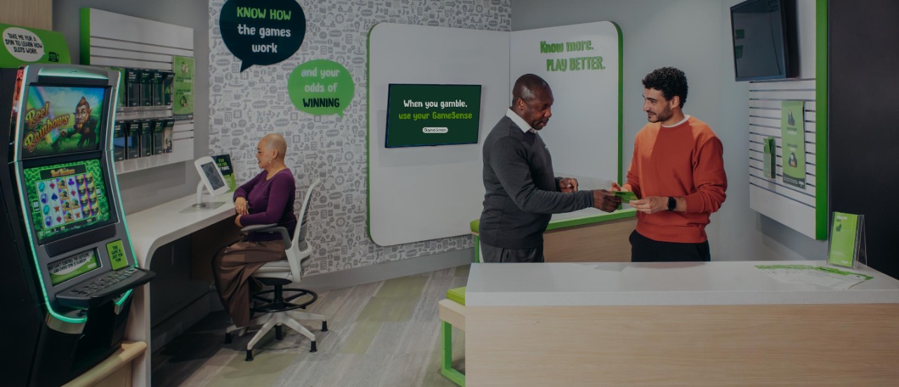 A GameSense Advisor talks with a player within a casino GameSense Info Centre.